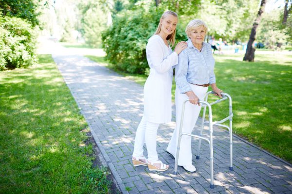 Clinician and her patient Pretty carer walking out with senior patient